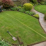 Landscaper measures an irregular lawn with a tape measure.